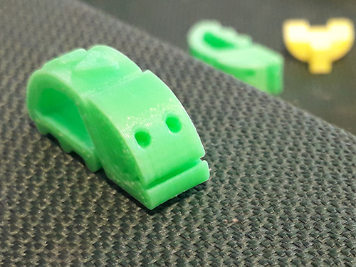 Foto: DKJS Grünfarbige Papierklemme aus Plastik in Form eines kleinen Käfers